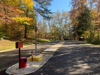 A blacktop road with red and yellow cables to the left.