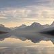 Lake McDonald with mountains in the background and pebble shore in the foreground.