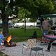 Young boy roasting marshmallows with adults watching at campsite.