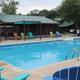 Outdoor swimming pool with colorful chairs and shaded seating areas.