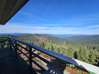 View from the Lookout with trees and hills and blue sky.