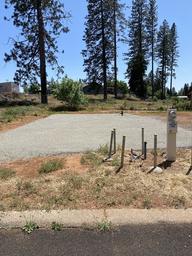 Another prepared RV pad with hookups and nearby trees — provides a different angle/landscape context for the park's RV spaces (matches on-site lot listings).