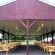 Covered picnic pavilion with multiple picnic tables under a roof, showing a common-use facility and campsite amenities. Source: Reservation Info & Directions page.