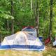 Tented campsite in a wooded site showing tent pads and surrounding trees—useful image of the campground’s tent camping areas from the 'ways to stay' gallery.