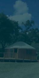 The image shows a yurt with a wooden deck, surrounded by trees under a blue sky with clouds.