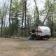 Individual RV pitch with picnic table and canoe visible nearby — good representation of a typical RV campsite on the property (from photo gallery).