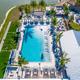 Close aerial/angled view focused on the main pool and club area with adjacent landscaping — highlights resort amenities and pool design (page context: resort amenities imagery).