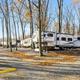 Large fifth-wheel trailer nestled among autumn trees
