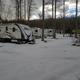 Shows several RVs on sites in a wooded area (winter/snow) — useful seasonal view of RV pitches and site spacing (source page: homepage https://shadybrookcg.com/).