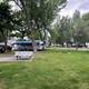 Wide view of green lawn, picnic table and multiple RVs in the background — good general overview of campground grounds and guest spacing; used as a background image on the property page.