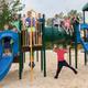 Playground area with play structures and children — useful to show on-site family facilities and play spaces for families considering the campground.