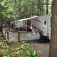 Seasonal RV/trailer site with deck, lattice privacy and trees — corresponds to the Seasonal Campsites page and shows full‑service hookup/seasonal camping setup on site.