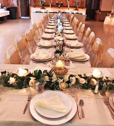 Interior banquet setup with long tables and place settings — shows the event/banquet facility available at the Raymond House venue (photo is on the venue homepage).