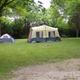 Tent camping area on grassy, treed site with picnic table and fire ring — illustrates tent campsites and natural setting (ways to stay photo).