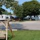 Wide daylight photo showing multiple RVs parked on level paved sites with grass, trees and a swing in foreground — clear overall view of the resort’s RV camping area (source: homepage image).