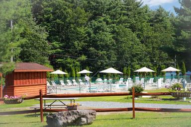 Outdoor pool area with lounge chairs and umbrellas — shows on-site recreation facilities and poolscape that appear on the property page.