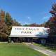 Entrance building of High Falls Park surrounded by autumn trees and green grass.