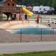 Large bounce pad/park area with playground and RVs in background — good view of activity area and adjacent RV sites (from Amenities page).
