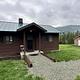 Historic forest service cabin with treed mountain behind.