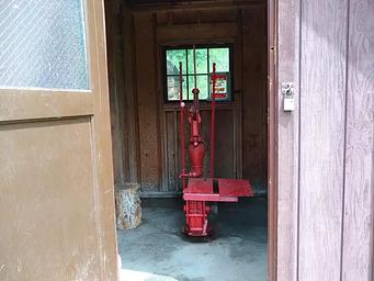 A water pump in a wooden pump house.