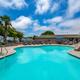 Wide shot of the resort swimming pool with surrounding lounge chairs and RV sites visible in the background — useful facility photo from the property gallery.