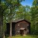 Wooden cabin/lodging on wooded grounds — useful to illustrate on-site lodging options and appears in the property’s lodging section context.