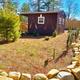 Small cabin or park building set within landscaped grounds and rock edging — from the property's Gallery page, useful to show on-site structures and landscaping.