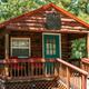 Exterior photo of a rustic cabin (Copper Cabin) on the property — shows cabin frontage, porch, and setting; originates from the site’s gallery and labeled as an on-site cabin.