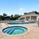 Ground-level photo of the pool area and clubhouse including hot tub and building — shows resort-style amenities and appears in the amenities gallery.