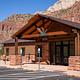 Campground reservation and wilderness permit office at South Campground in Zion National Park, with sandstone cliffs rising behind the building.