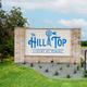 Entrance monument sign for The Hill Top at Brenham set at the property entrance — confirms property identity and arrival experience (homepage/gallery).