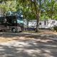 Shaded RV parking pads and large motorhomes on landscaped sites — clear photo of typical RV sites from the campground gallery.