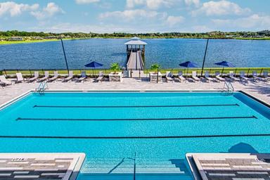 Pool-and-lake view from an elevated angle showing the swimming pool, pier and lakeside setting — highlights waterside amenities and vistas (gallery page).
