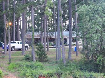 View through trees of the ship’s store/building and adjacent grounds—useful facility photo of on-site services.