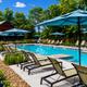 Pool and poolhouse photo with loungers and umbrellas — depicts on-site amenity and matches the site's Amenities page imagery for the property.