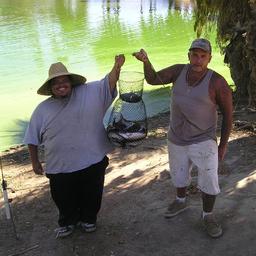 Two men proudly showing their catch at Reflection Lake.