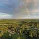 An aerial view of a river with a rainbow in the sky.