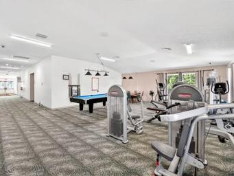 Interior image of the fitness / game room with equipment and pool table — documents indoor amenities available to guests; from the amenities page.