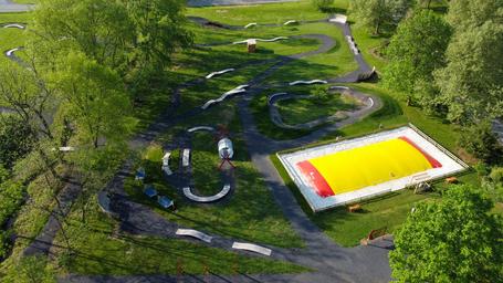 Aerial shot of on-site amenities including a large inflatable play pad and paved activity course—appears on the campground background/hero images for this KOA.