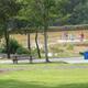 View from a deck showing the swimming pool, fencing and park grounds — useful for facilities/gallery. Source: ‘Cabins | Watts RV Park’ page (ratesPic1 social image).