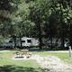 Panoramic shot of an RV campsite row with utility pedestals and picnic table — clearly depicts the park’s RV facilities referenced on the site’s family campground/RV park page.