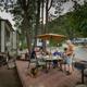 Patio/rv-site scene showing an RV, outdoor dining area and site hardscape — demonstrates a furnished RV/patio option and guest experience at the campground.