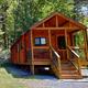 Clear photograph of a standalone cabin on site — directly supports the site’s ‘Cabins’ page content and shows cabin style and immediate surroundings.