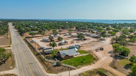 Aerial perspective including entrance road, clubhouse building and RV pads — clearly depicts site access, road frontage and RV pitching areas (from the property homepage).