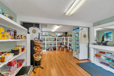 Interior photo of the campground store/office showing merchandise, coolers and counter area — useful to show on-site amenities and check‑in facilities.