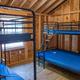 Interior shot of a cabin bunk room with multiple beds — useful to illustrate cabin sleeping arrangements and interior amenities (from cabin rentals photos).