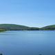 Wide panoramic lake view across a large body of water and surrounding hills — strong scenic overview consistent with the campground’s waterfront setting on the site.