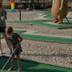Mini golf putting area with families and park-themed sculptures — shows on-site recreation facilities (appears in site gallery/slider).