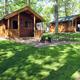 Photo showing two cabin units with picnic tables and fire ring area — useful to represent cabin lodging options on the grounds.