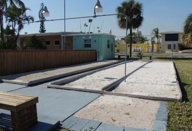 Photo of bocce/playing courts and nearby buildings — highlights on-site recreation facilities and layout of common areas.